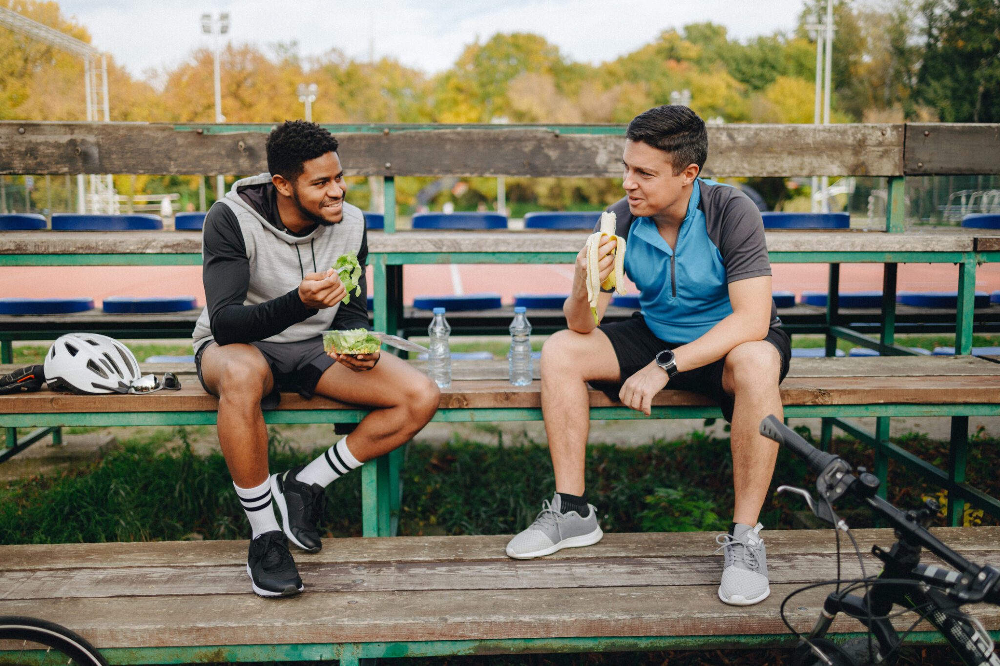 Two men enjoying sandwiches outdoors